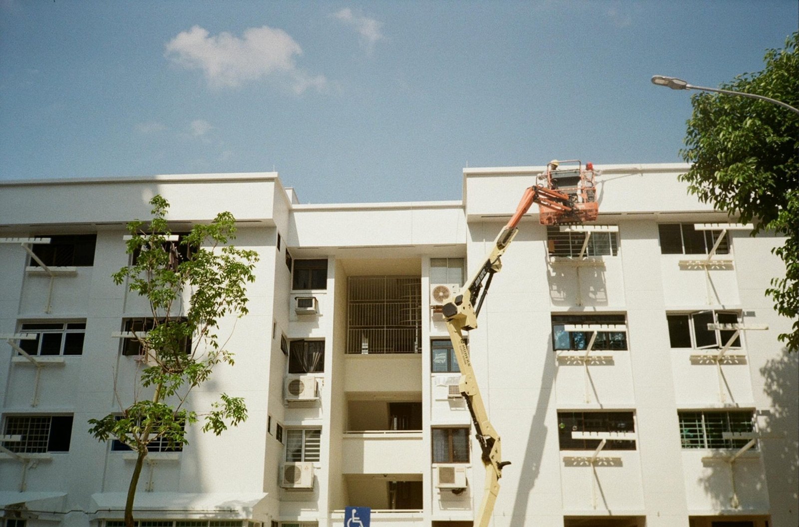 A partially constructed apartment building with scaffolding and HVAC system installation