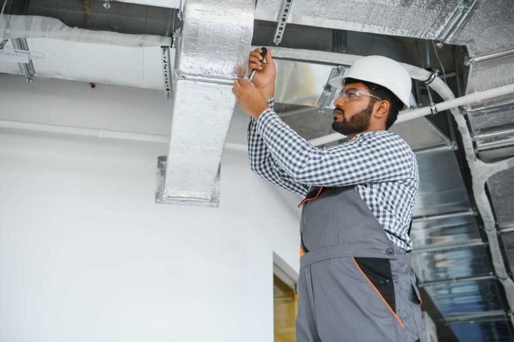 HVAC technician installing a ducted pipe system for ventilation maintenance